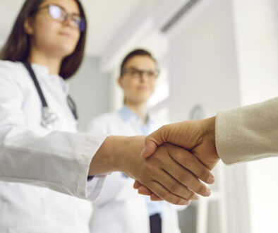 Closeup of a Female Nurse Shaking a New Patient's Hand With Another Nurse Standing Beside Her RMG Gastroenterology Accepting New Patients