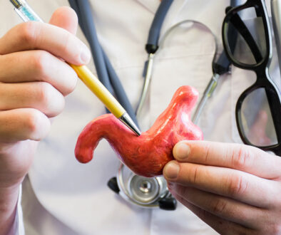 Closeup Of A Gastroenterologist Holding An Anatomical Model Of A Stomach Pointing To A Spot With A Pen Gastric Ulcers And Cancer